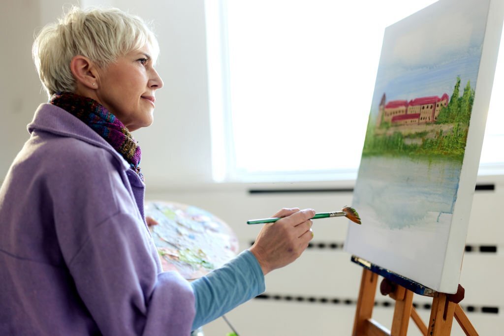 Foto van een oudere vrouw die schildert
